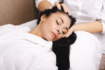 Fototapeta na wymiar Head massage for woman at spa salon. Rejuvenation treatment. Health care. Beauty skin female face.