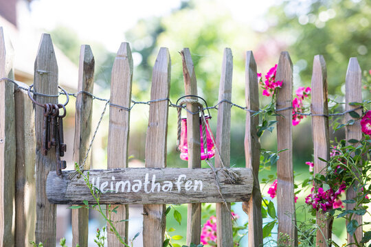 Wooden sign and old key ring hanging on rustic fence