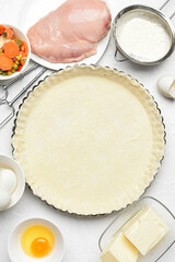 Raw dough and ingredients for preparing pot pie on white background