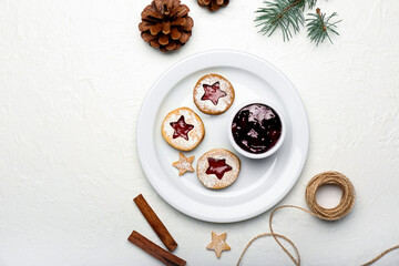 Plate with tasty Linzer cookies and jam on white background