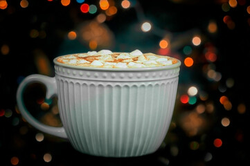 cup of chocolate or cocoa with marmalade against the background of flickering lights, blurry...