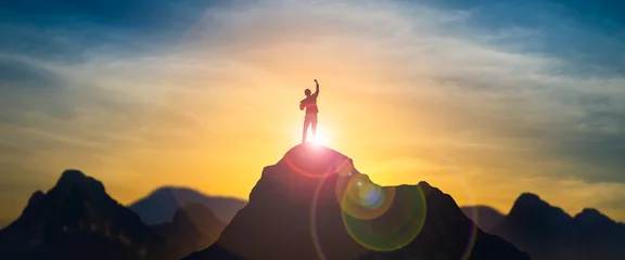 Foto auf Alu-Dibond Silhouette eines geschäftsmannes, der das heben der arme auf dem berggipfel mit über blauem himmel und sonnenlicht feiert. konzept der erfolgreichen führung mit ziel, wachstum, aufstieg, gewinn und zielvorgabe © Yingyaipumi