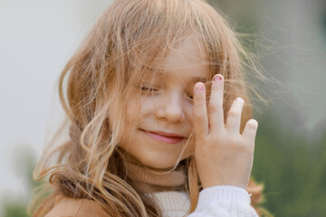 portrait of a cute girl dressed in autumn clothes with hair tangled from the wind