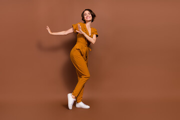 Fototapeta na wymiar Full body photo of cheerful positive woman dance rest free time cool isolated on brown color background