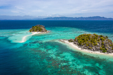 Aerial seascape tropical island and sand beach, turquoise water and coral reef. Malacory island in Palawan, Philippines.