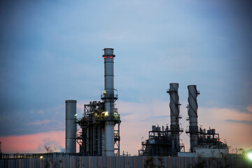 Oil refinery plant chemical factory and power plant with many storage tanks and pipelines at sunset.