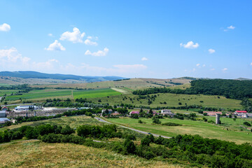 View from the stone walls at the Rupea Citadel (Cetatea Rupea) after renovation towards a small town in Brasov county, in the southern part of Transylvania (Transilvania) region, Romania in summer .