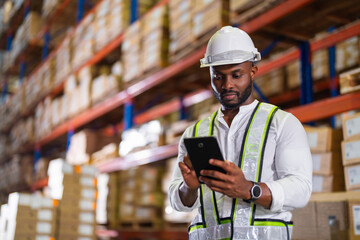 Warehouse worker working process checking the package with a tablet in a large distribution center....