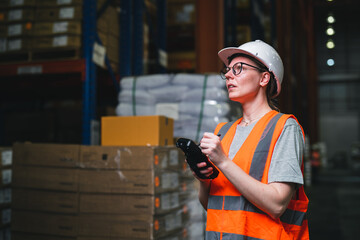 Warehouse worker working process checking the package using barcode reader in a large distribution center. Caucasian female inspects cargo inventory.