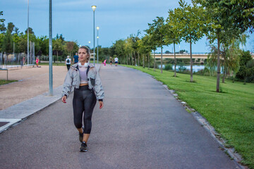 Sporty Woman.
40 Year Old Blonde Woman Walking Through A Park Doing Her Daily Exercise Routine