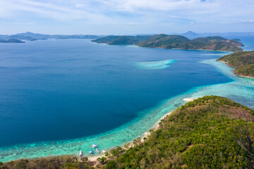 Aerial seascape tropical island and sand beach, turquoise water and coral reef. Malacory island in Palawan, Philippines.