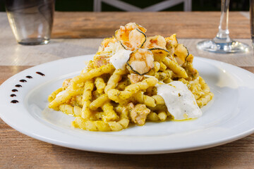 Fusilli alla nerano con zucchine fritte e provolone del monaco serviti come primo piatto in un ristorante