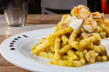 Fusilli alla nerano con zucchine fritte e provolone del monaco serviti come primo piatto in un ristorante