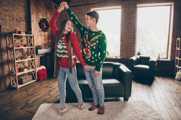 Full length body size view of attractive cheerful couple dancing spending time at home loft...