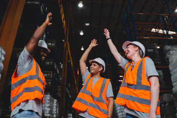 Obraz na płótnie Canvas A Group of Diversity warehouse workers giving hand for high-five after success the project and celebrating together in a distribution center warehouse.