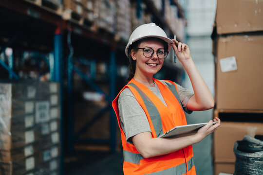 Portrait of a warehouse worker standing in a distribution center. Caucasian female looking at camera. concept of occupation and career.