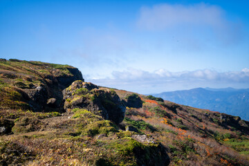 宮城県栗原市、秋田県湯沢市、雄勝郡東成瀬村、岩手県一関市にある栗駒山を紅葉の時期に登山する風景A view of climbing Mt. Kurikoma in Kurihara City, Miyagi Prefecture, Yuzawa City, Akita Prefecture, during the autumn foliage season.