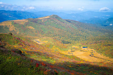 宮城県栗原市、秋田県湯沢市、雄勝郡東成瀬村、岩手県一関市にある栗駒山を紅葉の時期に登山する風景A view of climbing Mt. Kurikoma in Kurihara City, Miyagi Prefecture, Yuzawa City, Akita Prefecture, during the autumn foliage season.