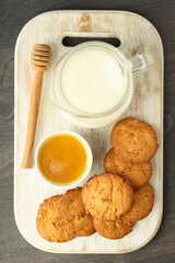 Milk, honey and pumpkin cookies on gray wooden table