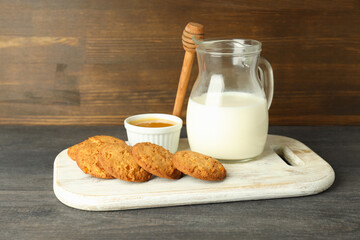Milk, honey and pumpkin cookies on gray wooden table