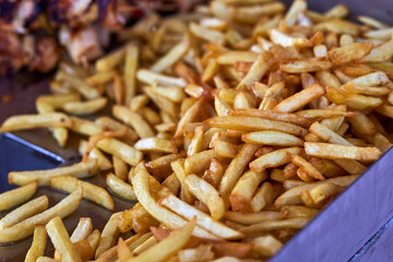 Deep fried French fries in fast food restaurant kitchen.Delicious snack for lunch cooked in hot oil for delivery.