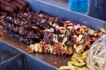 Grilled kebab cooking on metal skewer. Roasted meat cooked at barbecue. BBQ fresh beef meat chop slices. Traditional eastern dish, shish kebab. Grill on charcoal and flame, picnic, street food