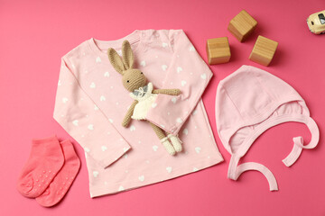 Concept of female baby clothes on pink background