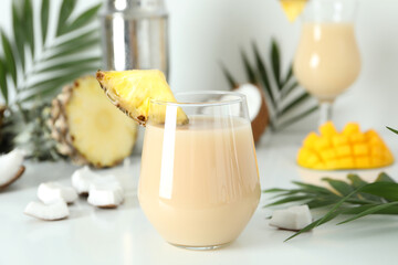 Pina colada cocktail and ingredients on white table