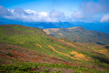 宮城県栗原市、秋田県湯沢市、雄勝郡東成瀬村、岩手県一関市にある栗駒山を紅葉の時期に登山する風景A view of climbing Mt. Kurikoma in Kurihara City, Miyagi Prefecture, Yuzawa City, Akita Prefecture, during the autumn foliage season.