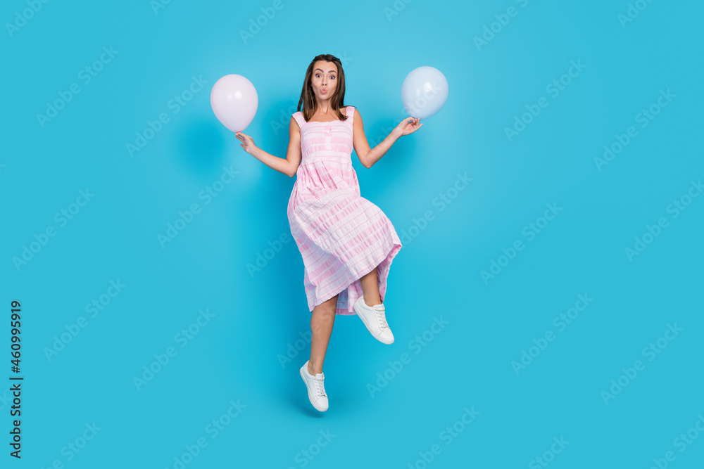 Wall mural Full size photo of brown haired attractive beautiful girl jump send air kiss hold balloons isolated on blue color background