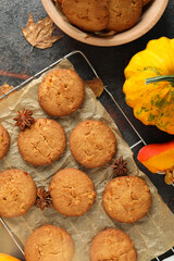 Concept of tasty food with pumpkin cookies on dark textured background