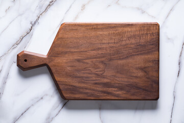 Handmade black walnut chopping board on stone table.