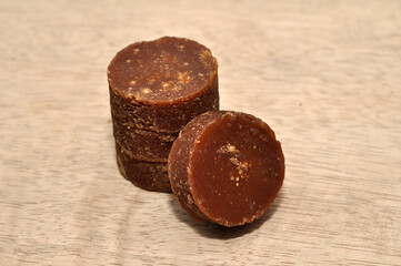 Coconut sugar or palm sugar in a round mold on a wooden board