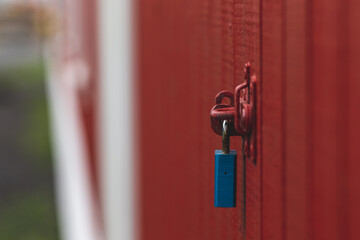 A blue padlock on a red door 