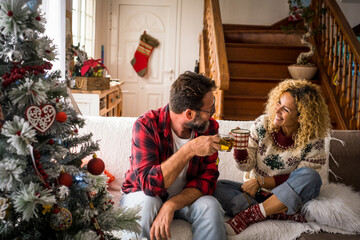 Happy couple toasting with coffee at home during Christmas