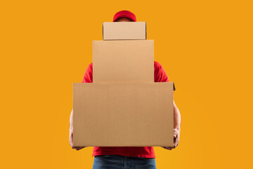 Unrecognizable Courier Holding Many Cardboard Boxes Delivering Packages, Yellow Background