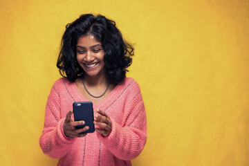 Beautiful Sri Lanka girl makes technology poses with yellow bright background - Young woman uses...