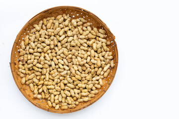 Raw peanuts in bamboo basket on white background.