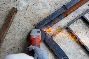 Close up, A man working with angle grinder. Iron gate repair