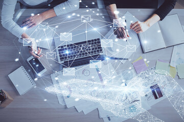 Double exposure of woman hands working on computer and envelop hologram drawing. Top View. E-mail...