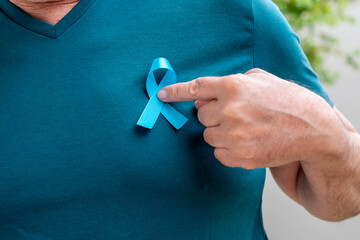 man hand holding blue ribbon. Blue november. Prostate Cancer Prevention Month. Men's health. blue...