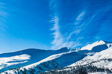 panorama of the snowy mountains with blue sky. mountain peaks covered with snow on a bright sunny day. winter landscape.