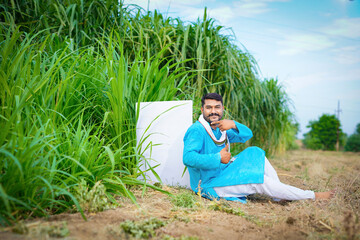 Indian farmer showing white board in agricultural field