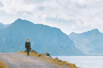 Woman hiking in Norway traveling solo with backpack vacations outdoor active healthy lifestyle explore Lofoten islands