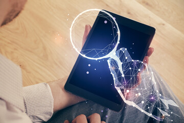 Double exposure of man's hands holding and using a mobile device and creative hologram drawing.