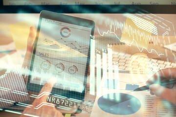 Double exposure of man's hands holding and using a digital device and tech theme hologram drawing. Technology concept.