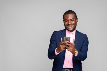 young businessman smiling while using his phone
