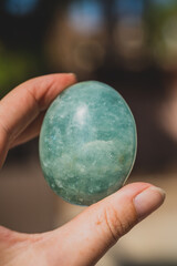 closeup of hand holding amazonite palm stone