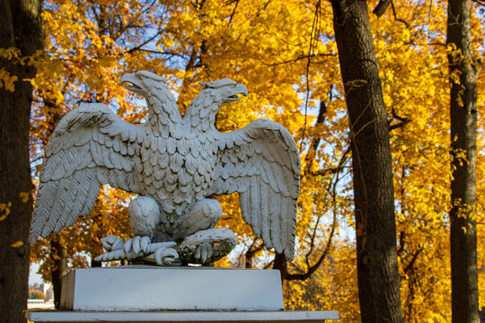 Sculpture of a double-headed eagle on the background of autumn foliage