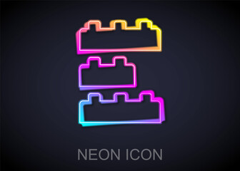 Glowing neon line Toy building block bricks for children icon isolated on black background. Vector